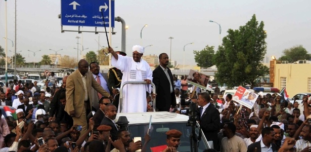 O presidente sudanês, Omar Hassan al-Bashir (de branco), cumprimenta seus partidários em Cartum, depois que autoridades não o prenderam por crimes de guerra e contra a humanidade emitido pelo Tribunal Penal Internacional nesta segunda-feira (15) - Marwan Ali/EFE