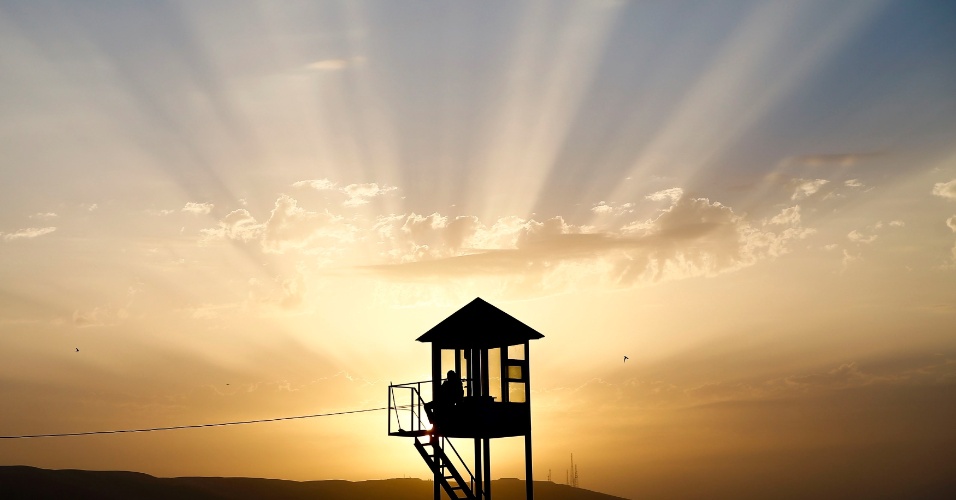 16.jun.2015 - Um policial monta guarda em uma torre de observação durante o pôr do sol em Baku, no Azerbaijão