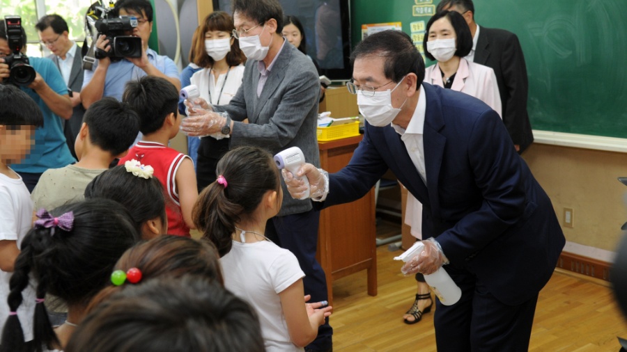Protegido com uma máscara, o prefeito de Seul mede a temperatura de alunos de escola fundamental - Xinhua