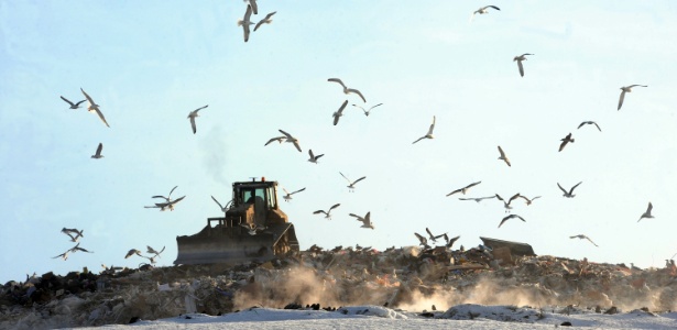 Trator move resíduos sólidos em aterro há 10km de São Petersburgo, na Rússia - Olga Maltseva/AFP