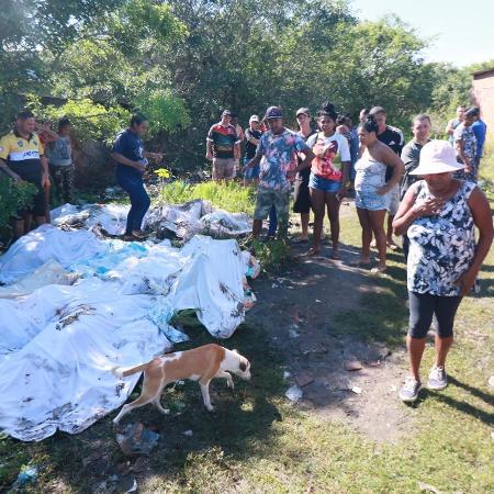 Moradores do Complexo do Salgueiro, em São Gonçalo (RJ), recolhem corpos em área de manguezal nesta segunda-feira (22), após operação da PM no último final de semana - Jose Lucena/Futura Press/Folhapress