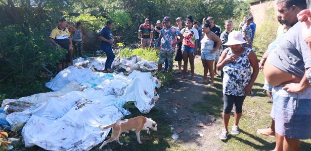 Moradores do Complexo do Salgueiro, em São Gonçalo (RJ), recolhem corpos em área de manguezal nesta segunda-feira (22), após operação da PM no último final de semana