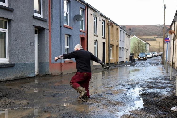 O morador Rob Scholes, 75 anos, caminha até sua casa por meio da lama que cobre uma rua, após a tempestade Bert, em Cwmtillery, Gales do Sul, Grã-Bretanha, em 25 de novembro de 2024.