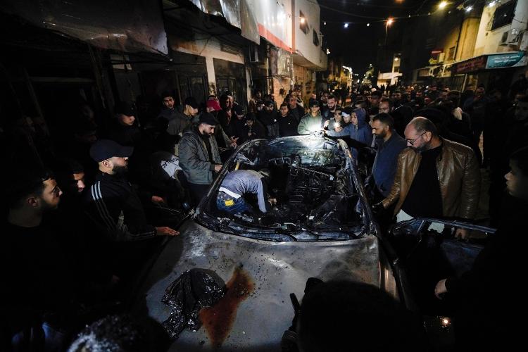 22.fev.24 - Pessoas inspecionam um carro queimado em Jenin depois que um palestino foi morto e outros quatro ficaram feridos em um ataque israelense