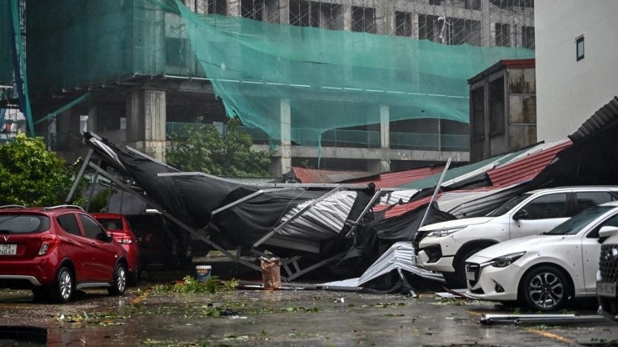 Carros ficam cobertos de destroços em um estacionamento depois que o Super Tufão Yagi atingiu Hai Phong em 7 de setembro de 2024 - NHAC NGUYEN/AFP