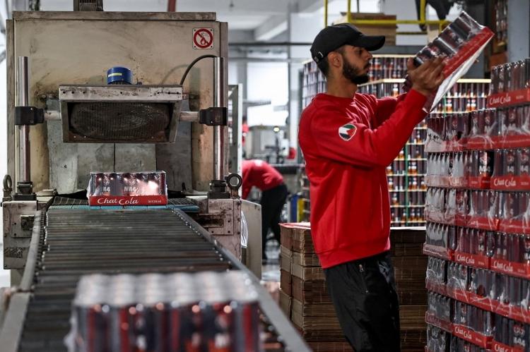 Funcionários trabalham na fábrica da empresa palestina de bebidas Chat Cola, na cidade de Salfit, na Cisjordânia