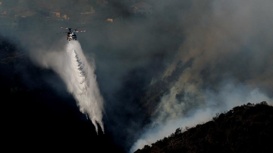 Um helicóptero faz um pouso enquanto a fumaça sobe do incêndio Palisades, que ameaça casas na área de Brentwood, em Los Angeles, Califórnia, EUA, em 11 de janeiro de 2025 - Shannon Stapleton/REUTERS