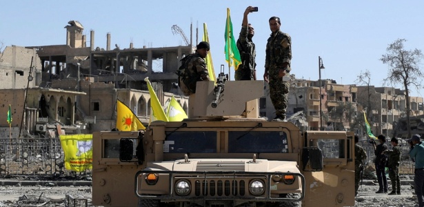 Soldado das Forças Democráticas Sírias faz uma selfie sobre carro militar em Raqqa, na Síria - Rodi Said/ Reuters