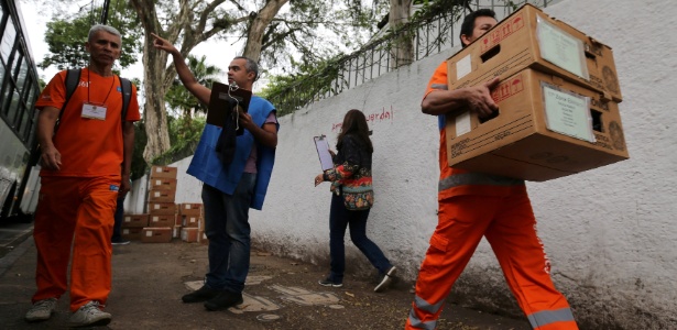 Funcionários de limpeza transportam urnas eletrônicas no Rio de Janeiro