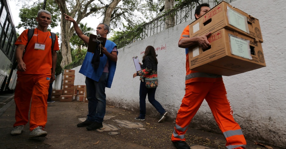 Funcionários de limpeza transportam urnas eletrônicas no Rio de Janeiro