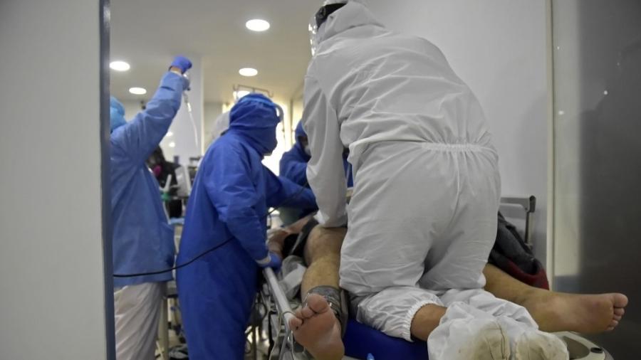 Médicos e enfermeiros entubam paciente com covid-19 em cidade próxima a Bogotá, na Colômbia - Raul Arboleda/AFP
