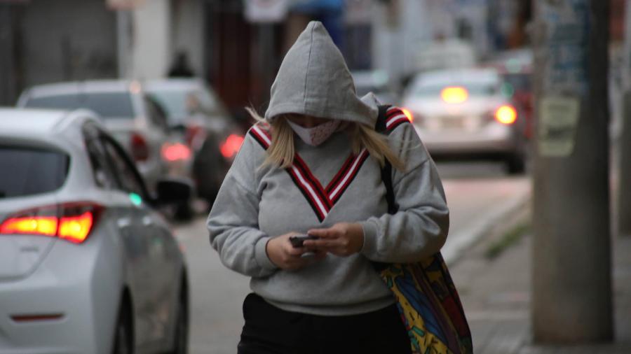 Mulher caminha bem agasalhada na rua Mulher caminha bem agasalhada na rua
