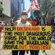 2.out.2021 - No Rio, casal exibe cartaz com frases em inglês criticando o governo de Jair Bolsonaro (sem partido), que seria o "vírus mais perigoso para o mundo". "Salvem os brasileiros. Fora, monstro", diz a mensagem - Marcela Lemos/UOL