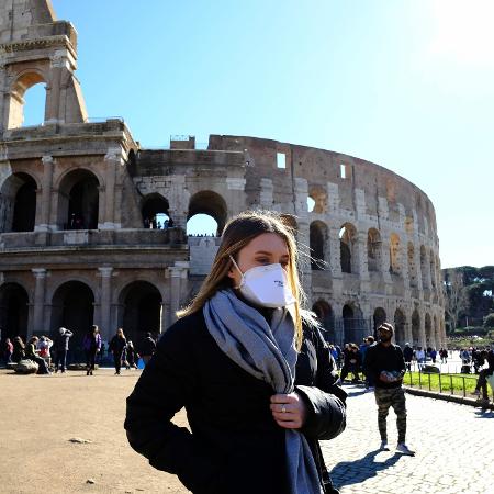 Preocupada com coronavírus, turista usa máscara de proteção perto do Coliseu, em Roma, uma das principais atrações turísticas da Itália - Andreas Solaro/AFP