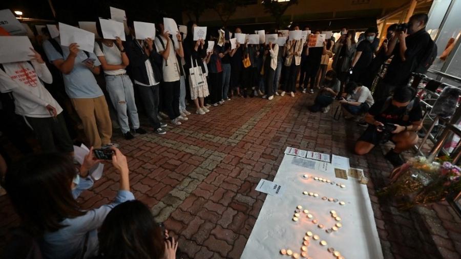 Estudantes em Hong Kong seguram papeis em branco como forma de protesto contra a censura na China, bem como contra a política de covid-zero do país - WILLIAM WEST/AFP