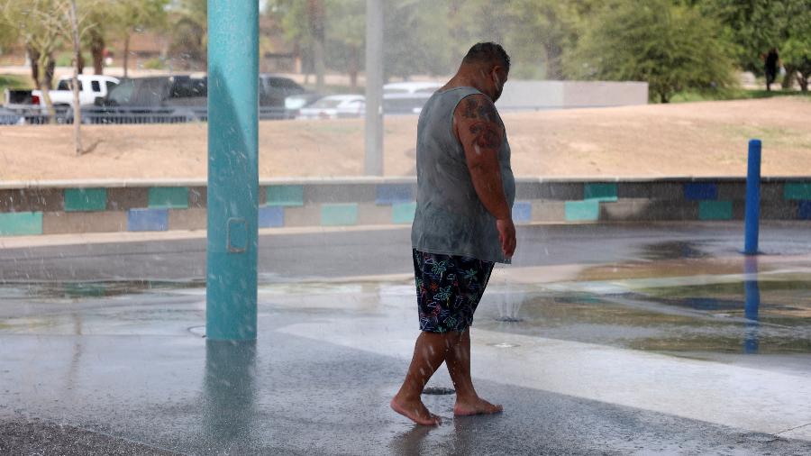 16.jul.2023 - Um homem se refresca em um parque aquático durante uma onda de calor em Phoenix, Arizona, EUA.