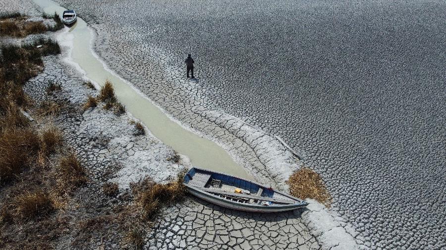 Homem caminha por área seca no Lago Titicaca, o maior da América Latina