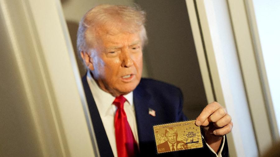 O presidente dos EUA, Donald Trump, segura o "gold card", oferecido a imigrantes estrangeiros ricos O presidente dos EUA, Donald Trump, segura o "gold card", oferecido a imigrantes estrangeiros ricos