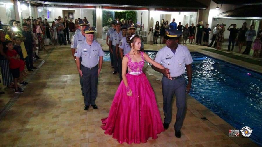 A jovem Lívia Caroline entra em sua festa de 15 anos acompanhada de policiais militares - Reprodução/Blog da PMESP