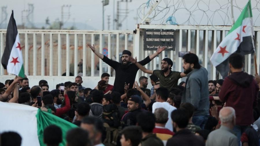 Manifestantes se reúnem na travessia de Bab al-Salama, na fronteira com a Turquia, na província de Aleppo, ao norte do país, em 17 de outubro de 2022, enquanto habitantes locais e outros das cidades de Azaz, Jarabulus, Mari e al-Bab, detidas pela oposição, tentam fugir do grupo jihadista Hayat Tahrir al-Sham (HTS) - BAKR ALKASEM/AFP
