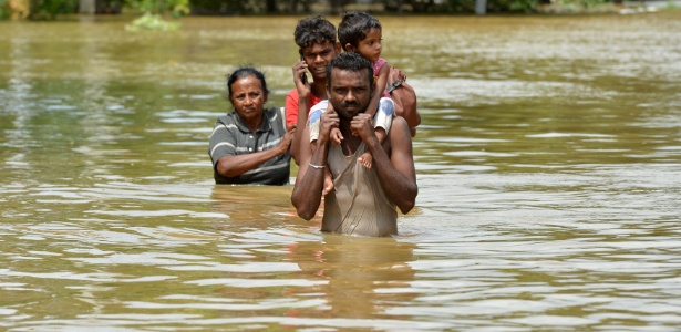 Moradores de Kaduwela, no Sri Lanka, caminham em meio a inundação  - Ishara S. Kodikara/AFP