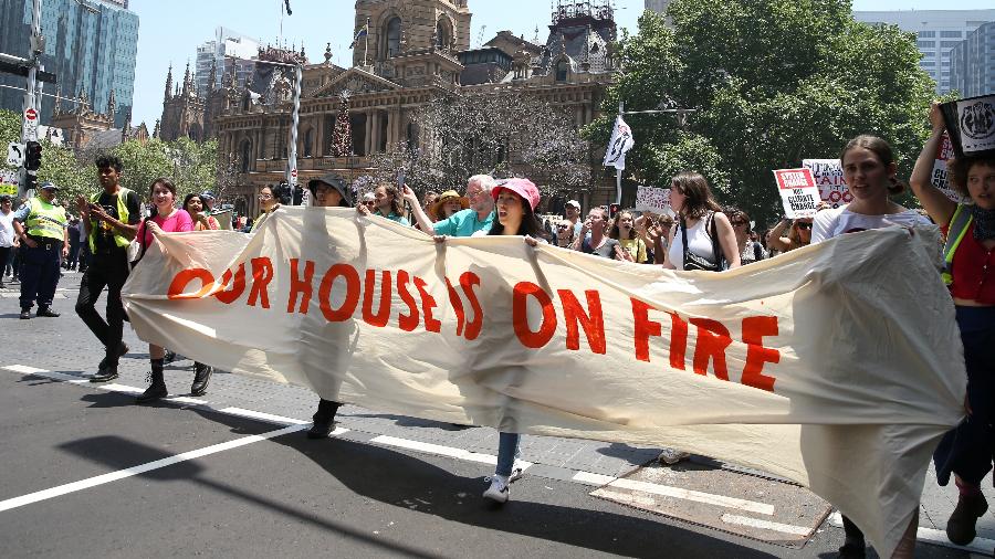 29.11.2019 - Estudantes fazem protesto por ação governamental contra o aquecimento global, na Austrália. Na faixa, a mensagem: "nossa casa está pegando fogo" - Getty Images