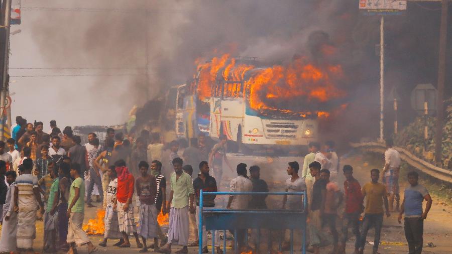 14.dez.2019 - Manifestantes colocam fogo em ônibus durante protesto contra nova lei de cidadania - STR/AFP