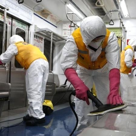 Funcionários limpando metrô na Coreia do Sul usando equipamentos de proteção individual - Getty Images - Getty Images