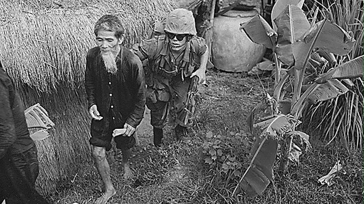 Soldado norte americano leva um suspeito vietcong durante uma operação de "limpeza" a oeste da base aérea de Da Nang (Vietnã) Soldado norte americano leva um suspeito vietcong durante uma operação de "limpeza" a oeste da base aérea de Da Nang (Vietnã)