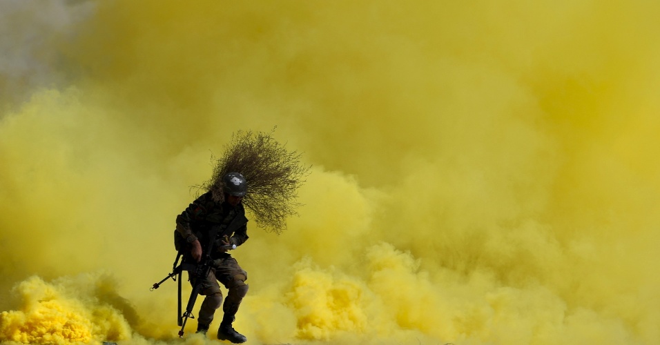 07.out.2015 - Soldado participa de exercício de treinamento militar com fumaça amarela no centro militar de Cabul, no Afeganistão