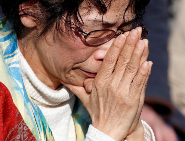 Mulher presta sua homenagem às vítimas com um minuto de silêncio às 2h46 em Tóquio - Toru Hanai/Reuters
