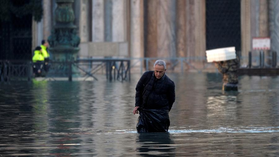 Homem caminha durante cheia em Veneza - Manuel Silvestri/Reuters