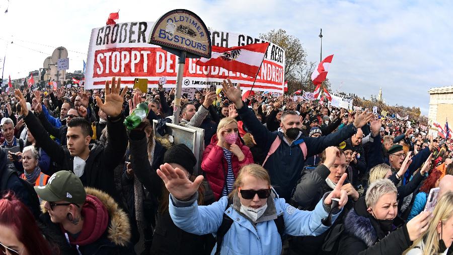 20/11/2021 - Manifestantes erguem faixas e cartazes durante um comício realizado pela FPOe (Partido da Liberdade), da extrema-direita austríaca, contra as medidas tomadas para conter a pandemia do coronavírus , na praça Heldenplatz em Viena, Áustria - Joe Klamar/AFP