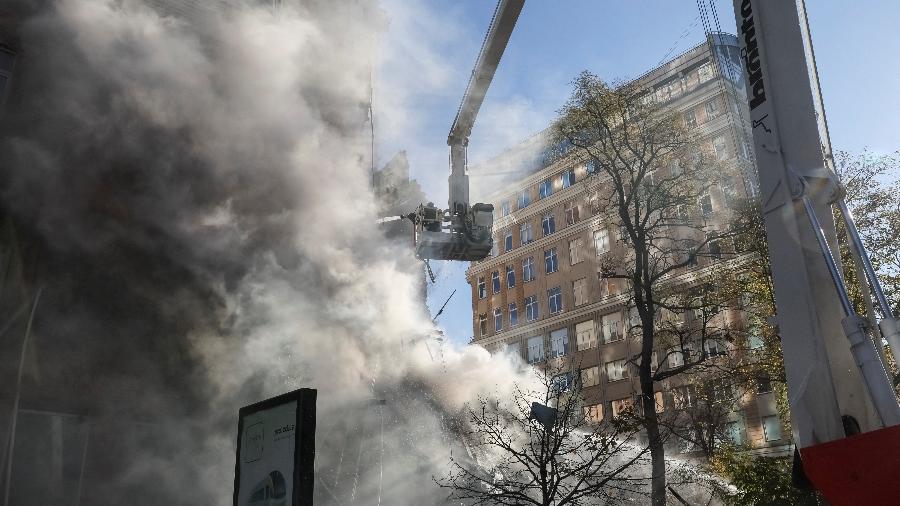 17.out.22 - Bombeiros ajudam uma mulher a sair de um prédio residencial destruído por um ataque de drone russo, que as autoridades locais consideram ser veículos aéreos não tripulados (UAVs) de fabricação iraniana Shahed-136 - GLEB GARANICH/REUTERS