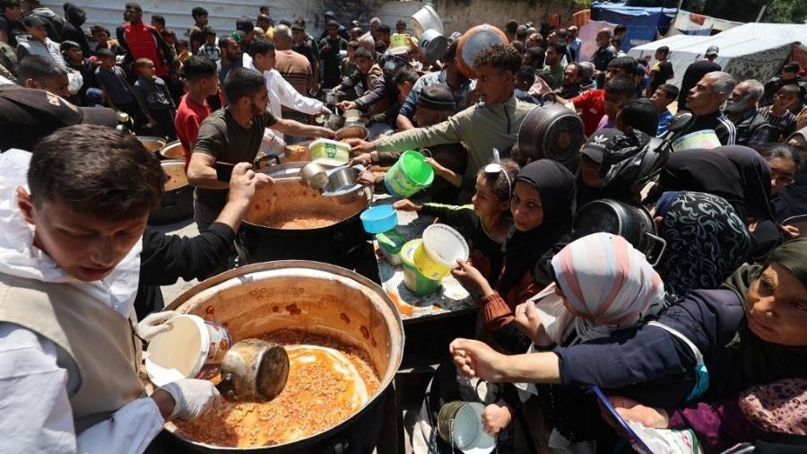 Palestinos fazem fila para receber comida no campo de refugiados de Nuseirat, na Faixa de Gaza Palestinos fazem fila para receber comida no campo de refugiados de Nuseirat, na Faixa de Gaza