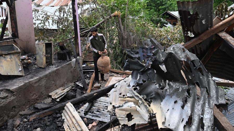 Homem tenta encontrar bens após ter casa destruída por ataques em Srinagar, na região da Caxemira Homem tenta encontrar bens após ter casa destruída por ataques em Srinagar, na região da Caxemira