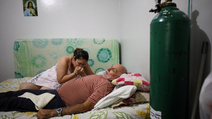 Osmar Magalhães recebe ajuda da filha Karoline Magalhães em sua casa, em Manaus - Bruno Kelly/Reuters