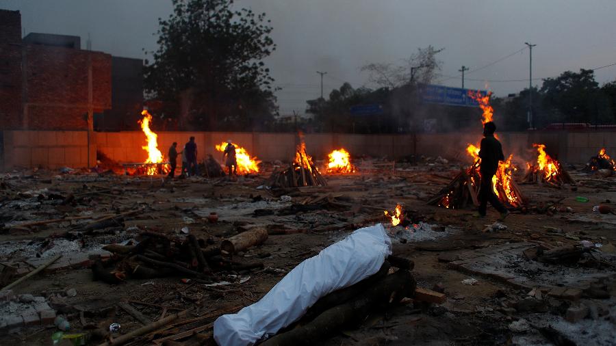 1/mai/2021 - Corpos são cobertos antes de cremação - REUTERS/Adnan Abidi