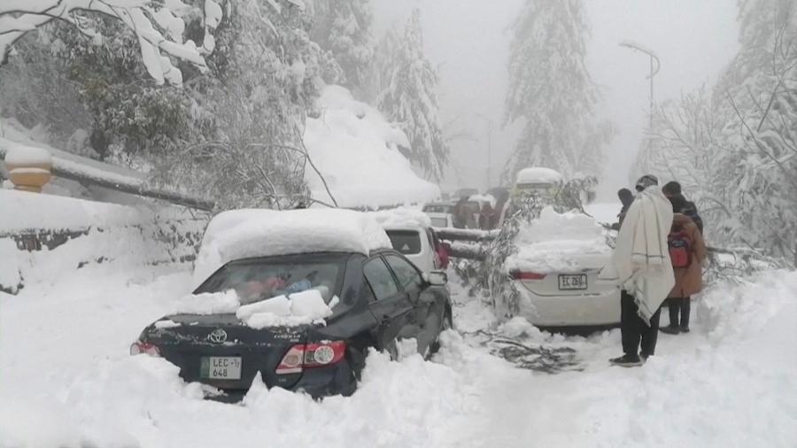 08.jan.22 - Carros ficam presos sob árvores caídas numa estrada de neve em Murree, nordeste do Paquistão - PTV/via REUTERS