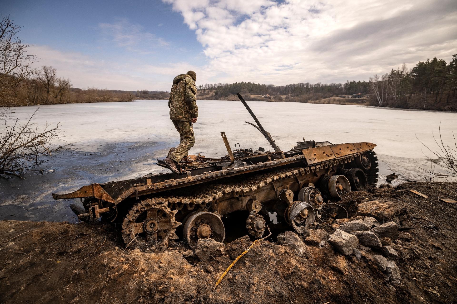 29.mar.2022 - A Ukrainian soldier stands next to a destroyed Russian tank in the northeastern town of Trostyanates - 29.mar.2022 - Fadel Senna/AFP