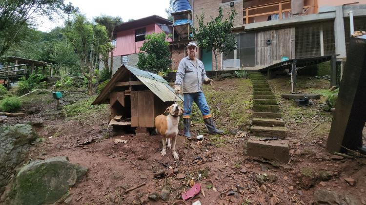 17.mai.2024 - José Carlos Borba com seu único cachorro sobrevivente em Caxias do Sul