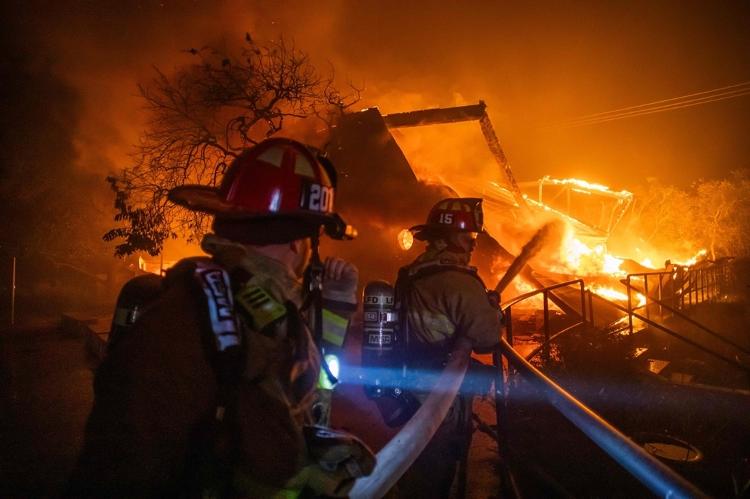 Bombeiros tentam conter as chamas de incêndio na vizinhança de Pacific Palisades, em Los Angeles