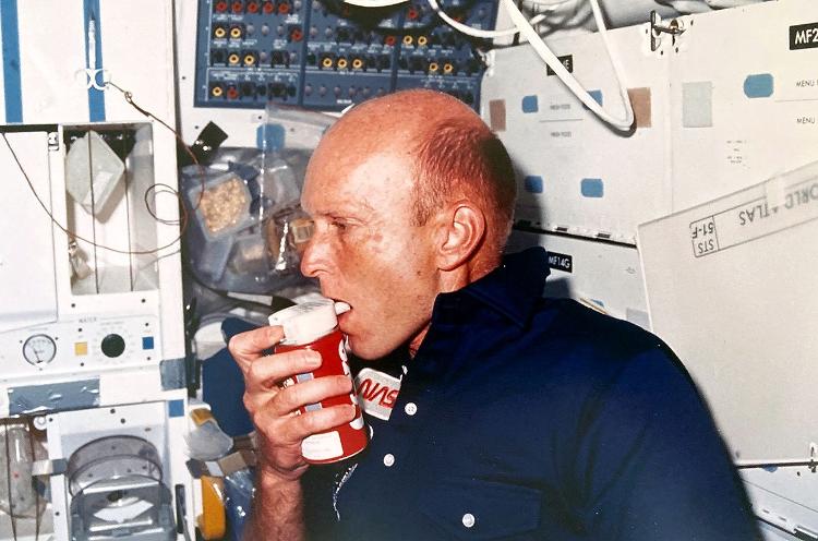 Gordon Fullerton, comandante da missão, tomando Coca-Cola no espaço