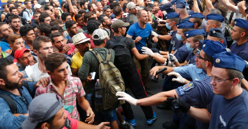 1.set.2015 - Policiais húngaros barram contêm imigrantes em estação de trem na capital do país, Budapeste. A a principal estação de trem da cidade foi fechada e todas viagens suspensas enquanto centenas de imigrantes aguardavam viagens para outros destinos da Europa