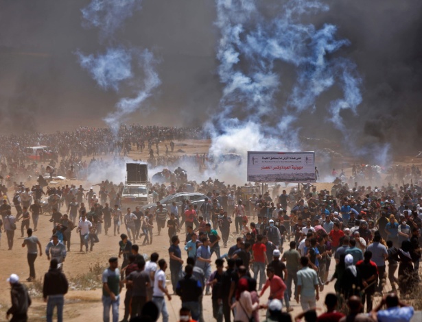 14.mai.2018 - Palestinos correm de bombas de gás durante protesto a leste de Jabalia, na fronteira da Faixa de Gaza com Israel - Mohammed Abed/AFP