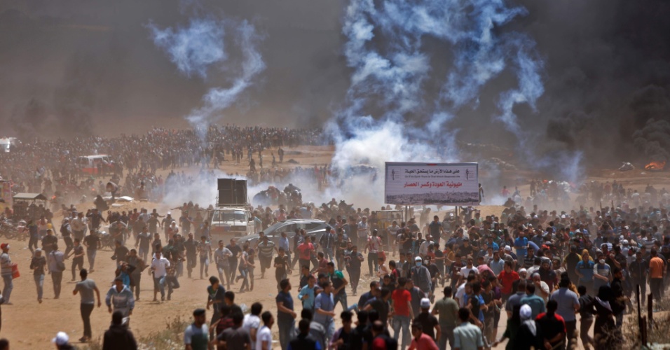 14.mai.2018 - Palestinos correm de bombas de gás durante protesto a leste de Jabalia, na fronteira da Faixa de Gaza com Israel