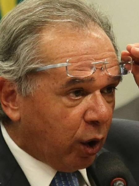 Paulo Guedes retira os óculos para fixar o olhar num ponto distante - Foto: Jorge William/Agência O Globo