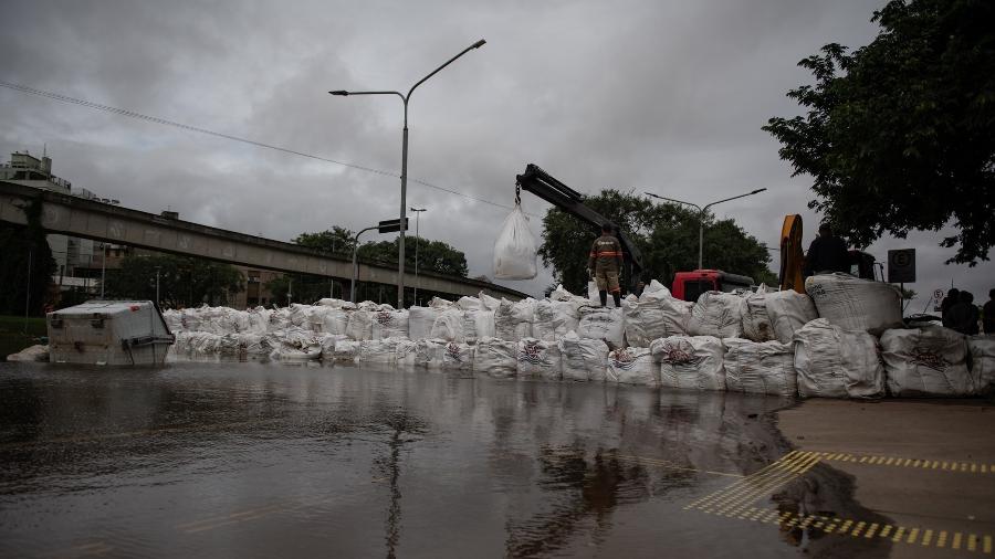 13.mai.2024 - Na foto, sacos de areia reforçam a barragem montada na Avenida Presidente João Goulart, em frente ao gasômetro de Porto Alegre (RS) - Gabriel Schlickmann/Folhapress