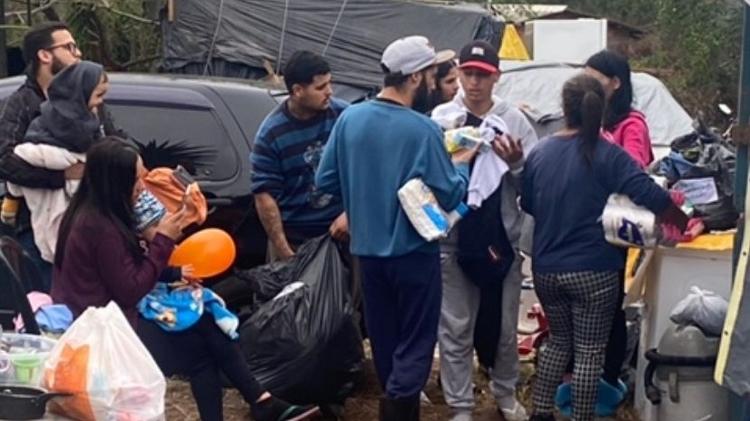 Em barracas às margens da BR-290, pessoas que tiveram as casas tomadas pelas chuvas dependem de doações para comer