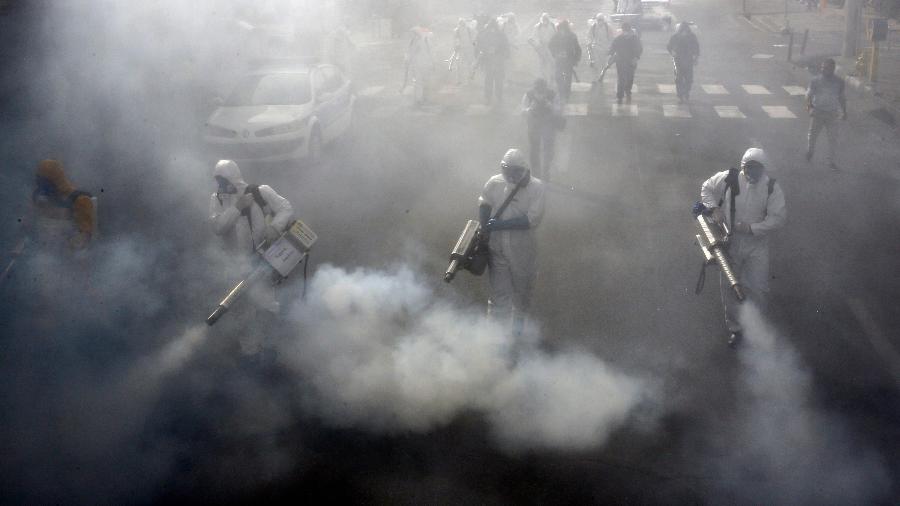 13 de março de 202: bombeiros iranianos desinfetam ruas na capital Teerã em uma tentativa de deter a disseminação do coronavírus